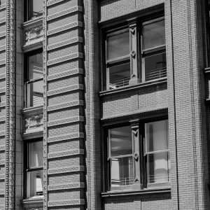 Black and white image of building exterior with sign that reads 