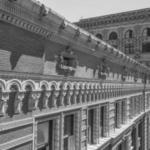 Black and white image of building exterior featuring intricate stone detail