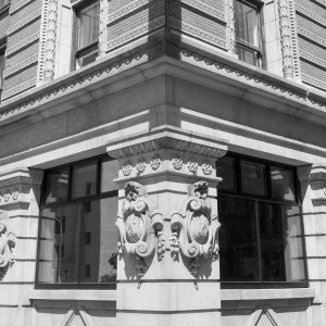 Black and white image of building exterior featuring intricate stone detail