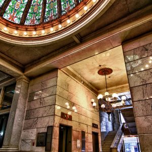 Building lobby with chandeliers and stone wall-to-wall